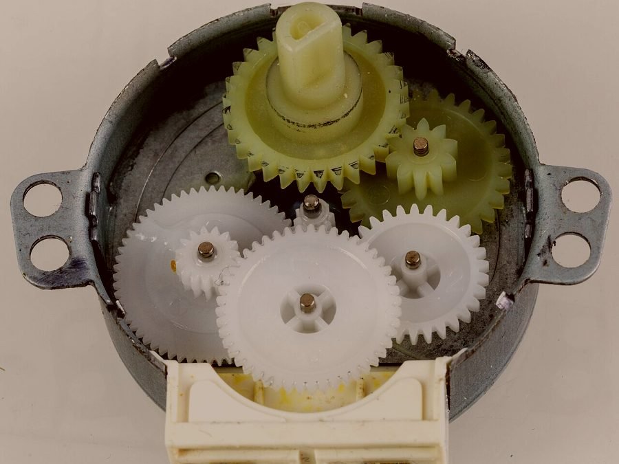 The nylon gear train out of a microwave turntable motor, opened on the bench